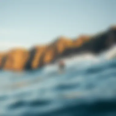 Riding the Waves: The Dance of Surfer and Sea Surfer navigating the waves against a backdrop of cliffs
