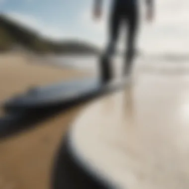 Close-up of a surfboard and wetsuit on the beach