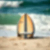 Surfboard resting on the shore with waves in the background
