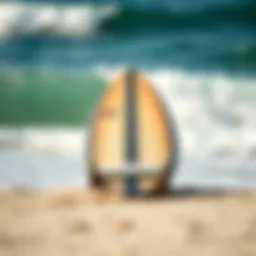 Surfboard resting on the shore with waves in the background