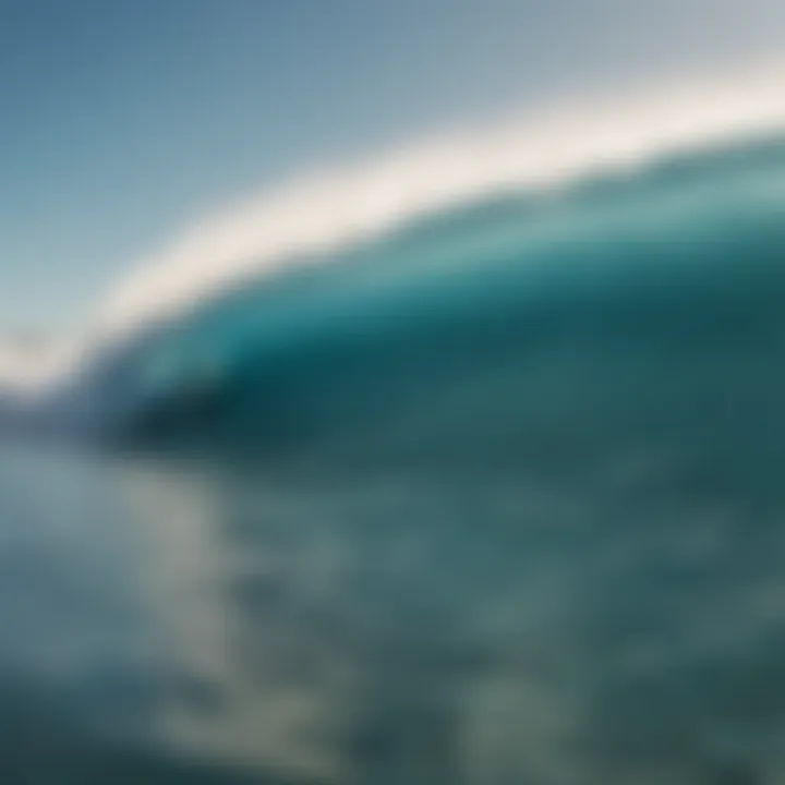 An aerial view of surfers riding waves under a clear blue sky.