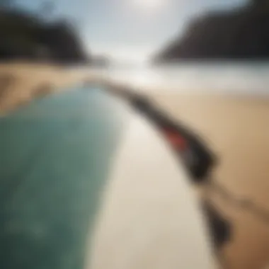 A close-up of surf equipment, including a well-worn surfboard and leash.