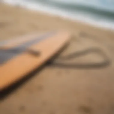 A close-up view of a longboard leash attached to a surfboard on a sandy beach