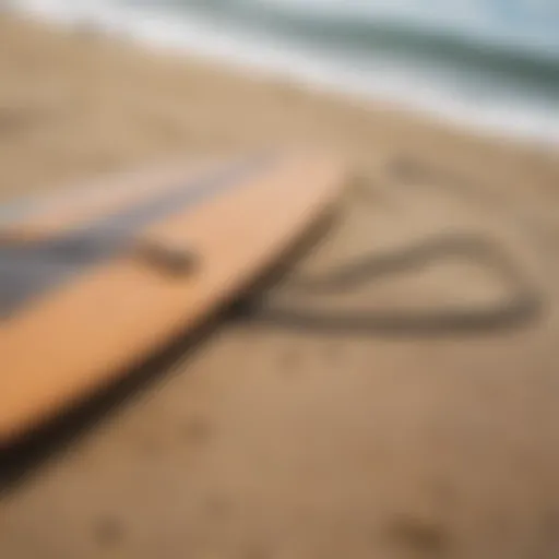 A close-up view of a longboard leash attached to a surfboard on a sandy beach